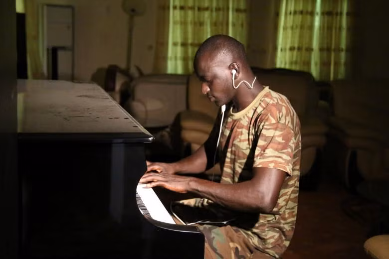 Một người lính Gambia chơi piano trong phòng của cựu Tổng thống Gambia