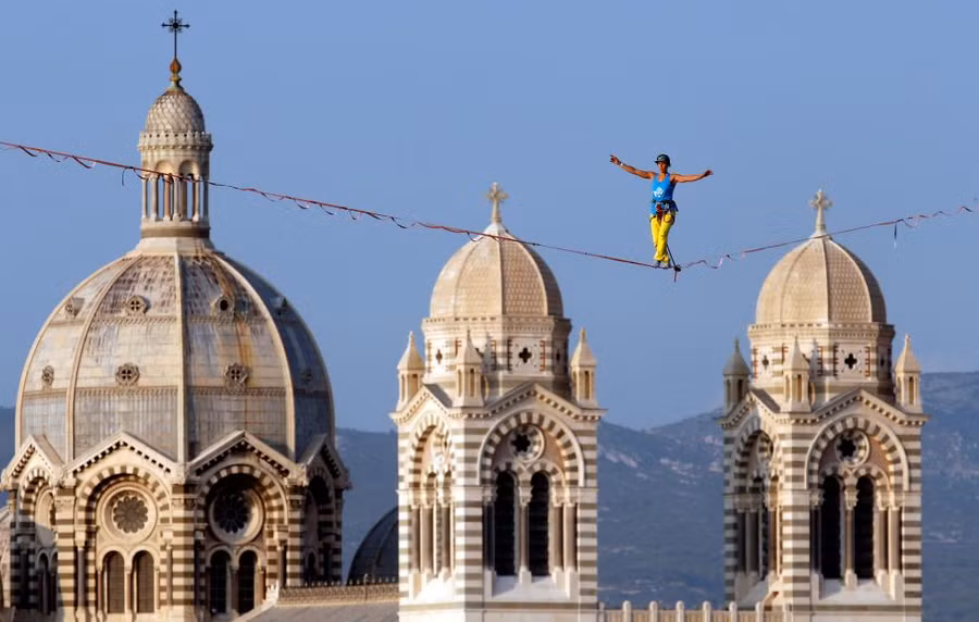 Một người biểu diễn đi trên dây ở trước nhà thờ Major tại Marseille, Pháp