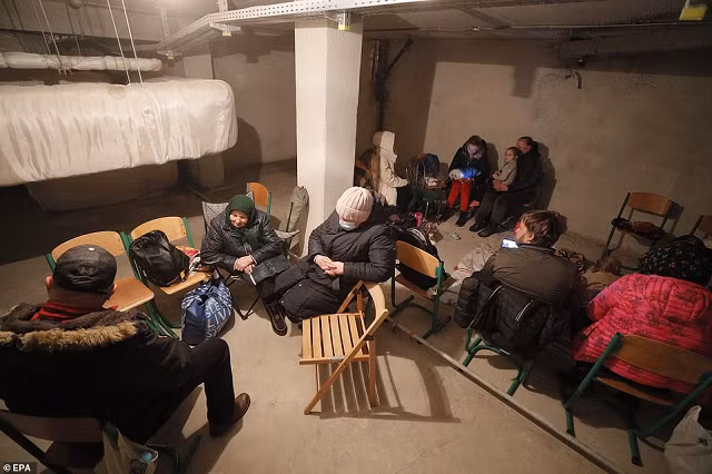 Mọi người sử dụng tầng hầm của một trường học làm nơi trú ẩn cho đêm tiếp theo ở Kiev.