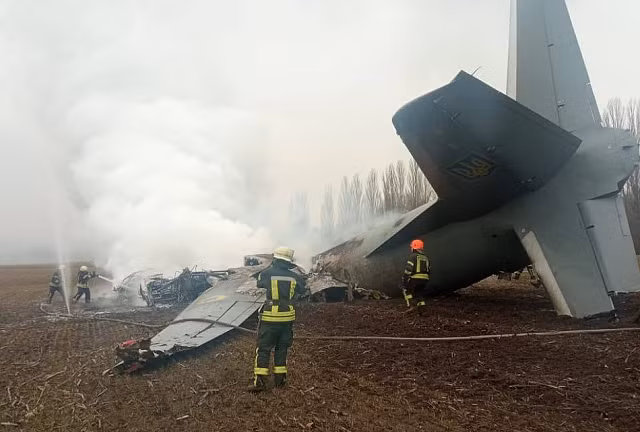 Lực lượng cứu hỏa Ukraine dập lửa ở phần còn lại của một máy bay vận tải của Lực lượng Không quân bị bắn rơi hôm nay.