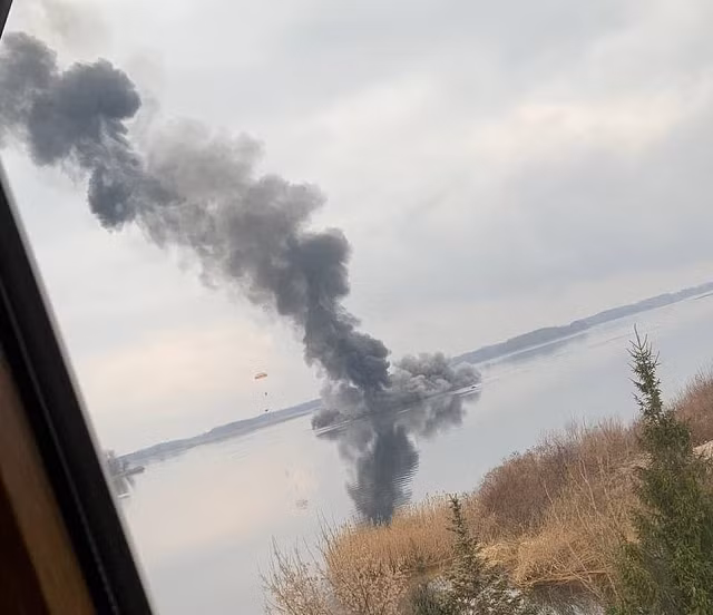 Hình ảnh được chụp gần Kiev cho thấy những gì dường như là mảnh vỡ của một máy bay trực thăng tấn công của Nga bị bắn rơi với một người lính nhảy dù ra khỏi nó (bên trái của khung hình)