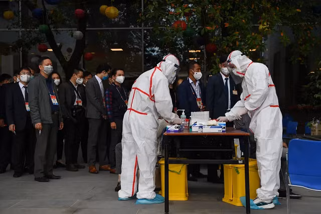 Nhân viên y tế mặc trang phục bảo hộ xét nghiệm COVID-19 cho nhân viên phục vụ Đại hội đại biểu toàn quốc lần thứ 13 của Đảng Cộng sản Việt Nam tại Trung tâm Hội nghị Quốc gia, Hà Nội ngày 29/1/2021