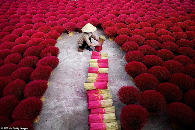 Một người phụ nữ Việt Nam đang gom nhang trong sân tại làng Quảng Phú Cầu ở ngoại ô Hà Nội Một người phụ nữ Việt Nam đang gom nhang trong sân tại làng Quảng Phú Cầu ở ngoại ô Hà Nội