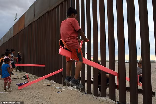Trẻ em Mỹ và Mexico chơi bập bênh qua biên giới Mexico với Mỹ tại khu vực Anapra ở Ciudad Juarez, bang Chihuahua, Mexico vào ngày 28 tháng 7.