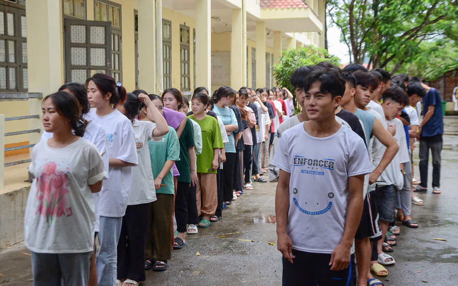 Sau tiếng còi của cô giáo Nguyễn Thị Tuế, học sinh xếp thành 2 hàng chờ đến nhận phần cơm của mình.