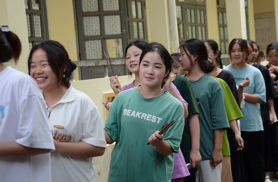 Sau tiếng còi của cô giáo Nguyễn Thị Tuế, học sinh xếp thành 2 hàng chờ đến nhận phần cơm của mình.