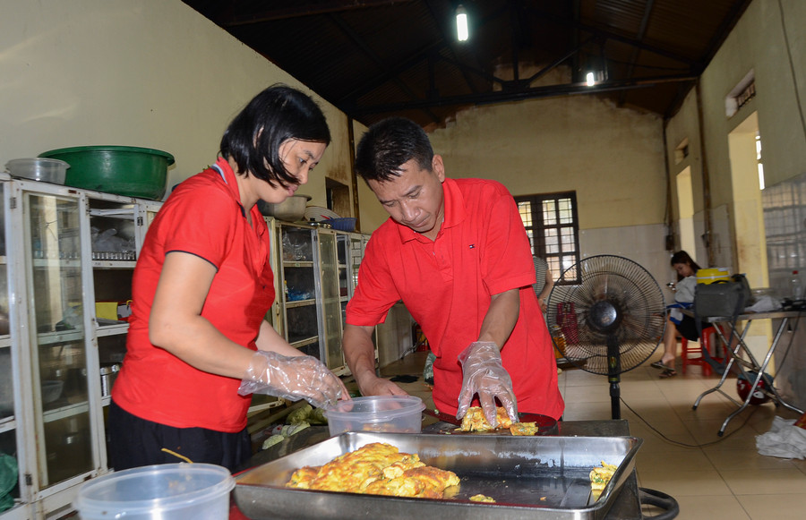 Giáo viên, phụ huynh tham gia nấu ăn miễn phí cho học sinh.