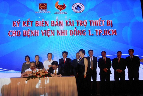 Ông Huỳnh Uy Dũng (ngồi, phải) ký kết tài trợ cho bệnh viện Nhi Đồng 1 TP.HCM
