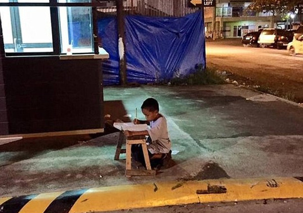 Sốt với ảnh bé gái mải mê làm bài tập trên bục chắn đường