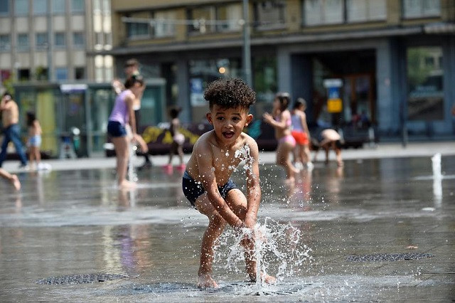 Một em bé chơi tại đài phun nước vào một ngày hè nóng nực ở Brussels của Bỉ - nơi nhiệt độ đạt mức kỷ lục 39,9 độ C hôm thứ 4