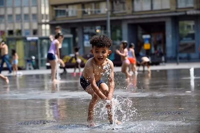 Một em bé chơi tại đài phun nước vào một ngày hè nóng nực ở Brussels của Bỉ - nơi nhiệt độ đạt mức kỷ lục 39,9 độ C hôm thứ 4
