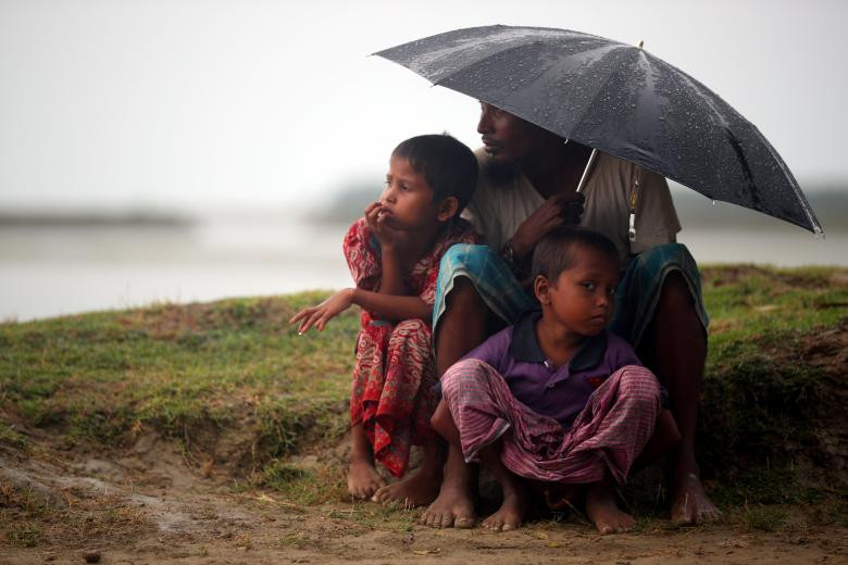 Người tị nạn Rohingya trú mưa khi chờ được quân đội Bangladesh cho phép đi qua biên giới Bangladesh – Myanmar.