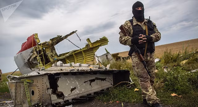 Một binh sĩ đứng cạnh xác máy bay Boeing 777.