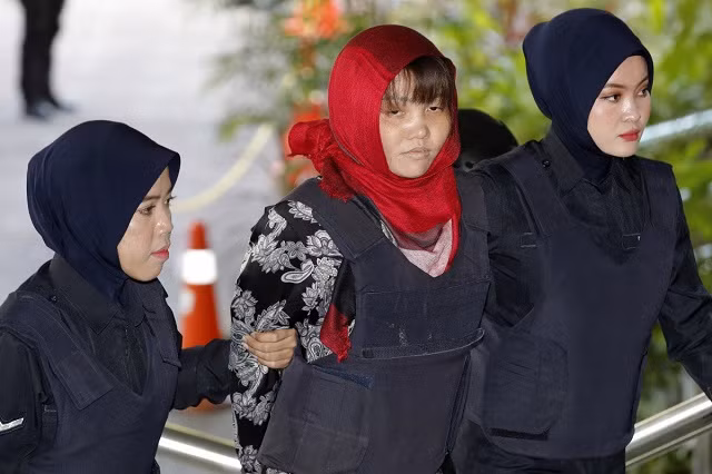 Đoàn Thị Hương (giữa) mặc áo chống đạn khi đến tòa hôm nay