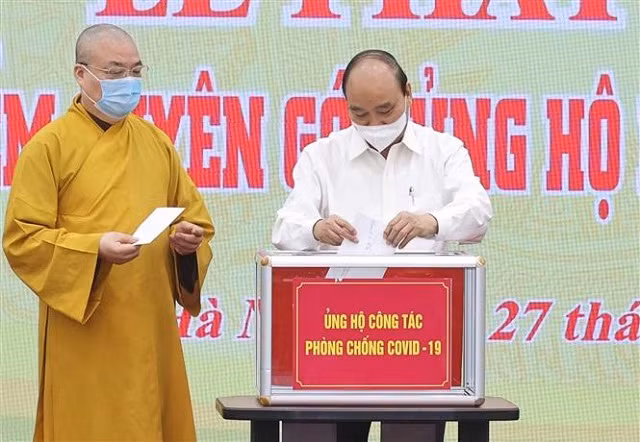 Chủ tịch nước Nguyễn Xuân Phúc quyên góp ủng hộ phòng, chống dịch COVID- 19. Ảnh: Thống Nhất/TTXVN.
