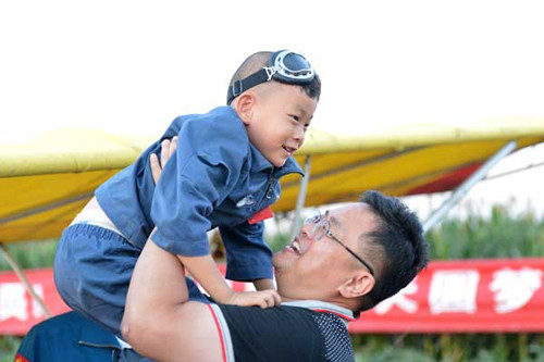 Duoduo và bố, He Liesheng, vui mừng sau chuyến bay dài 30 phút thành công của cậu bé. Ảnh: China Daily
