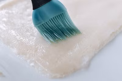 Phết thêm một lớp dầu ăn mỏng lên mặt trên của bánh rồi cắt bánh phở ra thành sợi.