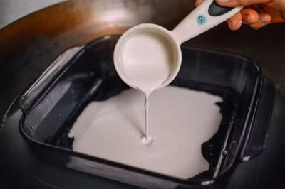 Chuẩn bị một chiếc nồi đáy sâu lớn, nếu không có thì thay bằng nồi lớn cũng được nhưng phải chú ý kẻo nước bị tràn. Cho nước vào nồi, sau đó đặt khuôn sứ chịu nhiệt vào trong như hình.Bật lửa đun cho đến khi nước sôi. Phết phủ một lớp dầu ăn lên khuôn. Sau đó đổ bột vào khuôn, cố gắng tráng thật mỏng và đều tay.