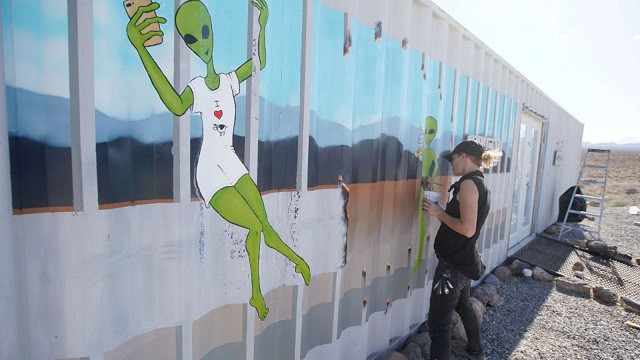 Một họa sĩ đang vẽ hình ảnh người ngoài hành tinh.