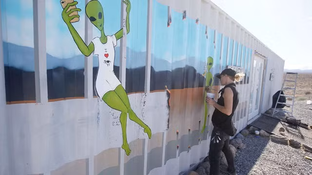 Một họa sĩ đang vẽ hình ảnh người ngoài hành tinh.