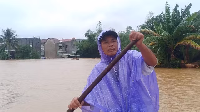 Ông Trần Văn Hóa đang chèo ghe đến nhà các hộ dân.