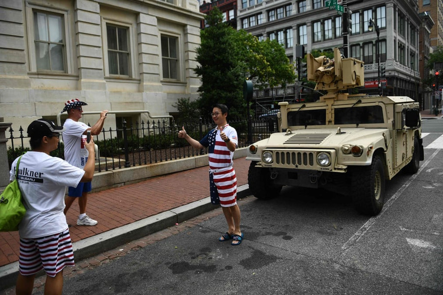 Người dân tạo dáng trước một xe bọc thép Humvee quân sự đậu trên một con đường ở thủ đô Người dân tạo dáng trước một xe bọc thép Humvee quân sự đậu trên một con đường ở thủ đô