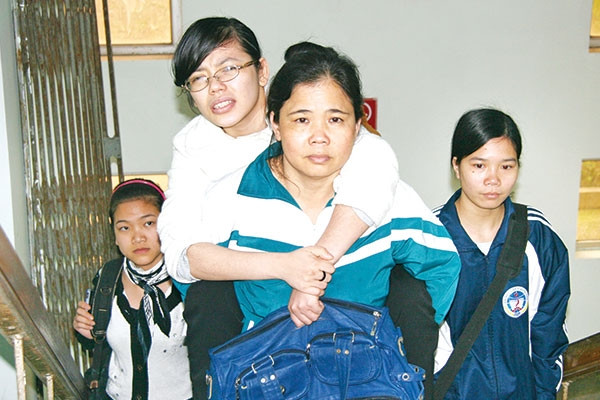 Cô Nguyễn Thị Nguyệt, mẹ của Yến hàng ngày cõng con đến giảng đường 9