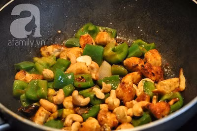 Chờ đến khi thịt gà chín, cho ớt chuông và hạt điều vào. Chừng 1 phút sau thì tắt bếp, nhắc xuống.