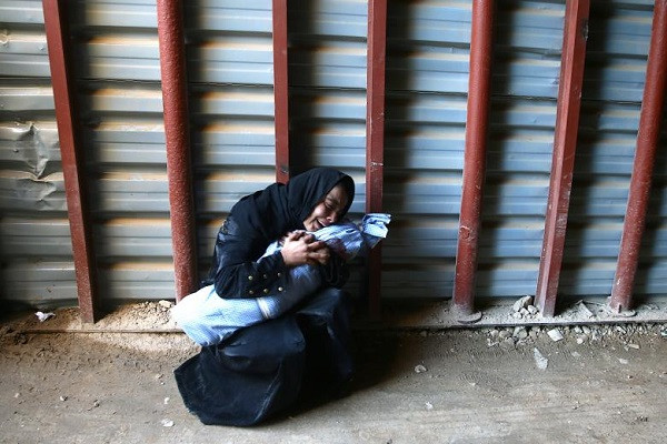 Cô Heba Amouri ôm thi thể đứa con trai 2 tuổi của mình tại một trung tâm y tế ở Douma, Syria.