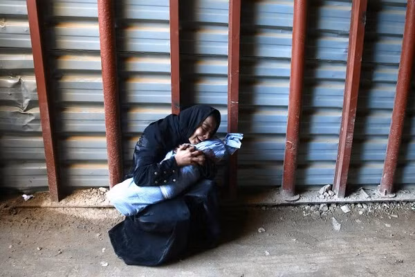 Cô Heba Amouri ôm thi thể đứa con trai 2 tuổi của mình tại một trung tâm y tế ở Douma, Syria.