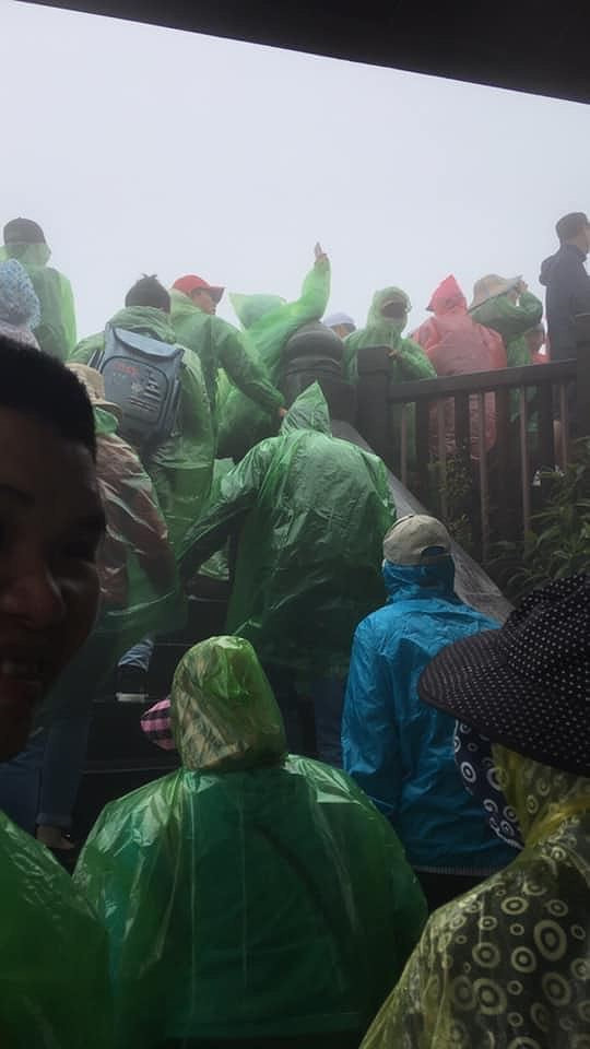 ...Cảnh chen chúc diễn ra ở đỉnh Đỉnh Fansipan, thời tiết mưa phùn du khách phải mặc áo mưa.