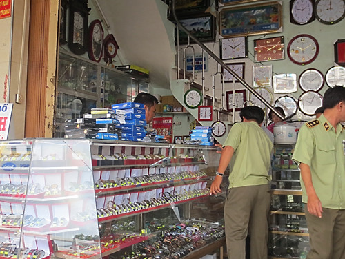 Cơ quan chức năng đang kiểm tra hàng giả tại một cửa hàng tại TP HCM. polyad