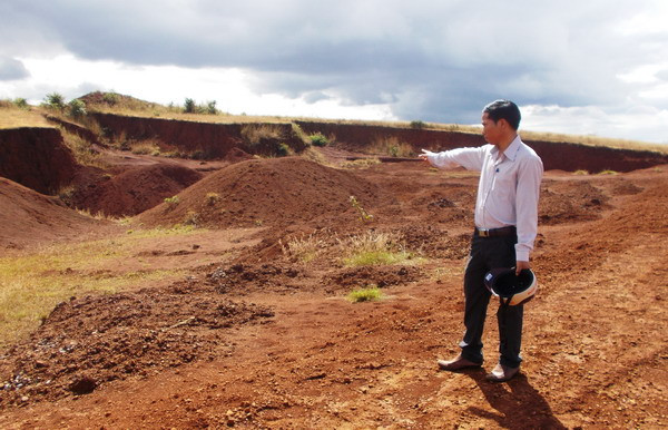 Ông Chủ tịch xã đang chỉ những chổ đất sạt lở vì dự án triệu đô này.
