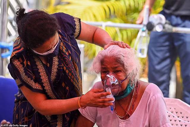 Một người già thở oxy bên ngoài bệnh viện.