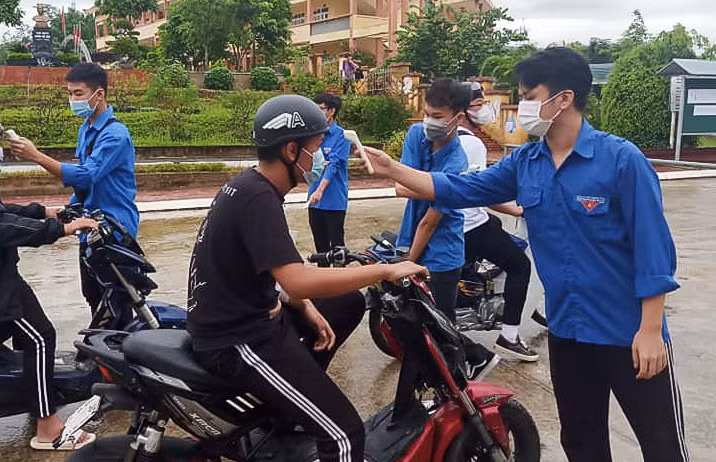 Thí sinh đến dự thi tuyển sinh lớp 10 được đo thân nhiệt và yêu cầu đeo khẩu trang, sát khuẩn.