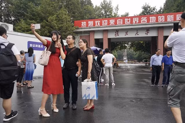 Tân SV chụp ảnh với cha mẹ khi tới trường ĐH