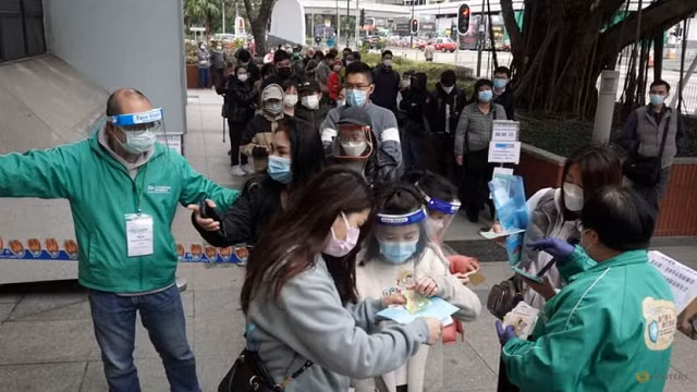 Các bậc cha mẹ Hong Kong đưa con đi tiêm chủng Covid-19.