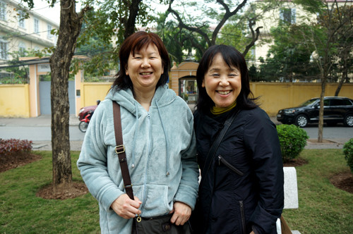 Hai người phụ nữ tỏ ra ngạc nhiên và òa lên thích thú khi nhìn thấy những người bán hoa đào trên phố.