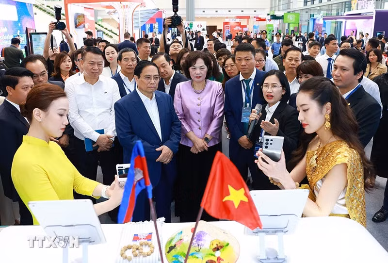 Thủ tướng Phạm Minh Chính tham quan trưng bày về ứng dụng chuyển đổi số trong lĩnh vực ngân hàng. (Ảnh: Dương Giang/TTXVN)