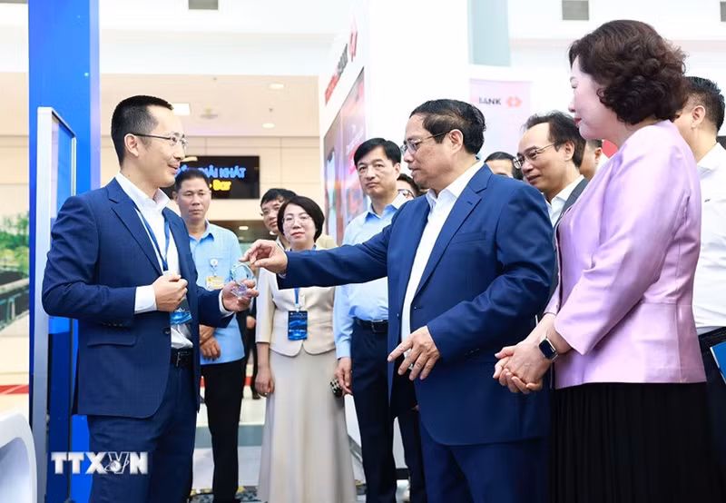Thủ tướng Phạm Minh Chính tham quan trưng bày về ứng dụng chuyển đổi số trong lĩnh vực ngân hàng. (Ảnh: Dương Giang/TTXVN)