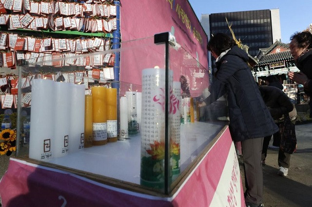Một phụ huynh cầu cho con thi tốt tại Đền Jogye ở Seoul, Hàn Quốc. Một phụ huynh cầu cho con thi tốt tại Đền Jogye ở Seoul, Hàn Quốc.