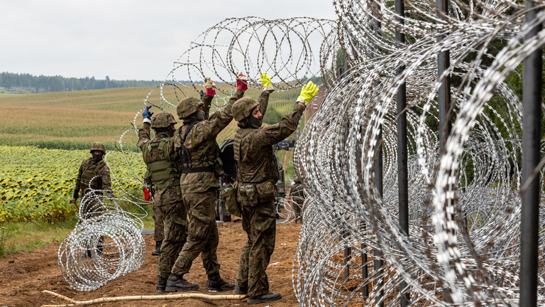 Lính Ba Lan dựng hàng rào bằng dây kẽm gai ở biên giới Belarus. (Ảnh: Getty Images)