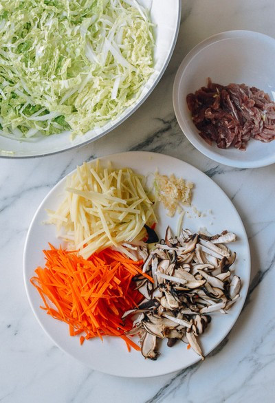 Sơ chế các nguyên liệu: cà rốt, măng thái sợi. Nấm cắt nhỏ. Bắp cải bào sợi. Thịt bò cắt nhỏ, ướp sơ với một chút muối, tiêu và dầu mè. Sơ chế các nguyên liệu: cà rốt, măng thái sợi. Nấm cắt nhỏ. Bắp cải bào sợi. Thịt bò cắt nhỏ, ướp sơ với một chút muối, tiêu và dầu mè.