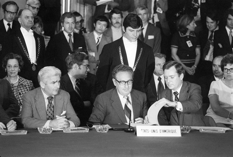 Ông Henry Kissinger (giữa), cố vấn của Tổng thống Mỹ Nixon về các vấn đề an ninh quốc gia, ký một thỏa thuận ngừng bắn chấm dứt chiến tranh Việt Nam tại Paris, Pháp ngày 13/6/1973. (Ảnh: AFP). Ông Henry Kissinger (giữa), cố vấn của Tổng thống Mỹ Nixon về các vấn đề an ninh quốc gia, ký một thỏa thuận ngừng bắn chấm dứt chiến tranh Việt Nam tại Paris, Pháp ngày 13/6/1973. (Ảnh: AFP).