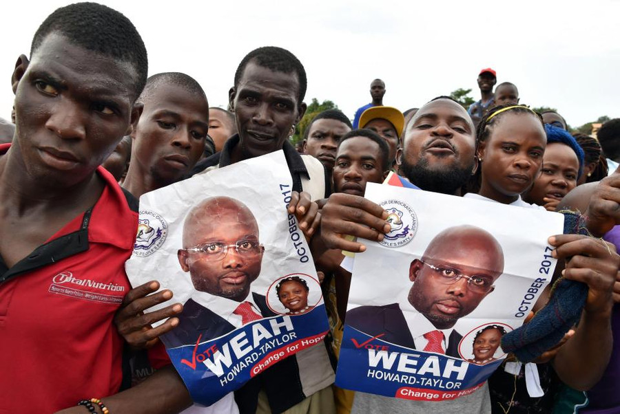 Những người vận động bầu cử George Weah cầm poster của ông