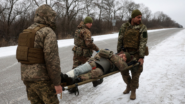 Nhân viên y tế của Quân đội Ukraine sơ tán một binh sĩ bị thương trên con đường không xa Soledar, vùng Donetsk. (Ảnh: Anatolii Stepanov / AFP