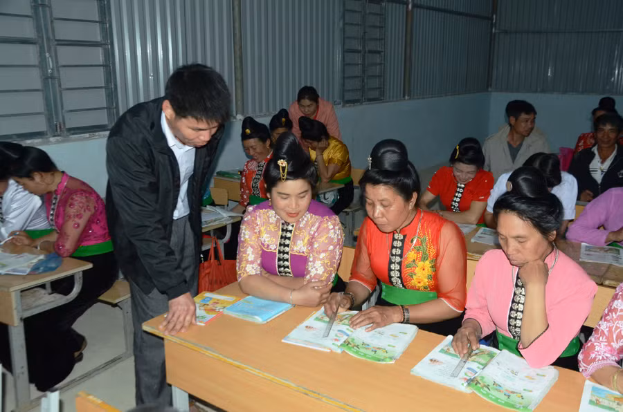 Giáo viên Trường PTDTBT Tiểu học Luân Giói hỗ trợ học viên lớp xóa mù chữ tại bản Na Cai.