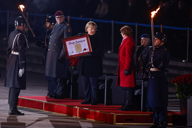 Bà Merkel nhận chứng nhận trong đại quân lễ.