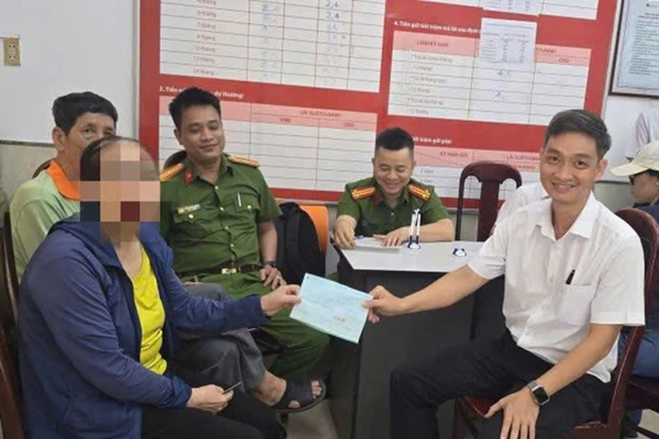 Lực lượng Công an và nhân viên ngân hàng làm thủ tục trao tiền lại cho bà P. Ảnh: CACC