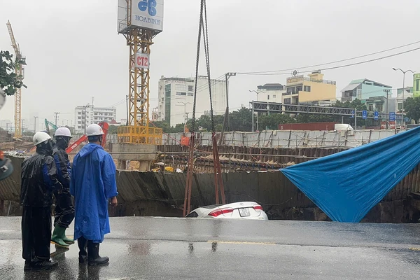 Lực lượng chức năng phong tỏa hiện trường vụ sụt lún làm 2 ô tô rơi xuống hố ở trung tâm TP Đà Nẵng. 